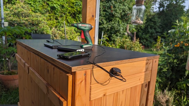 Outdoor-Küchenschrank unter unserem Gartenpavillon mit angebauter USB-Ladebuchse.
Im Schrank eingebaut: Solarladeregler und 100Ah-Solarakku.