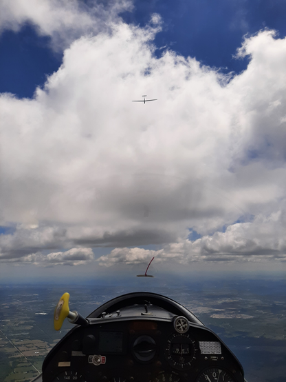 The view of a glider silhouetted against the clouds from another glider.
