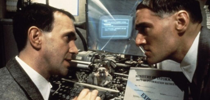 Two men in business suits face each other in front of a device that is an anachronistic mash-up of mechanical typewriter, early PC display, and magnifying glass.