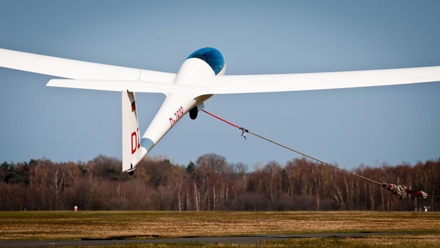A glider being launched via a winch cable.